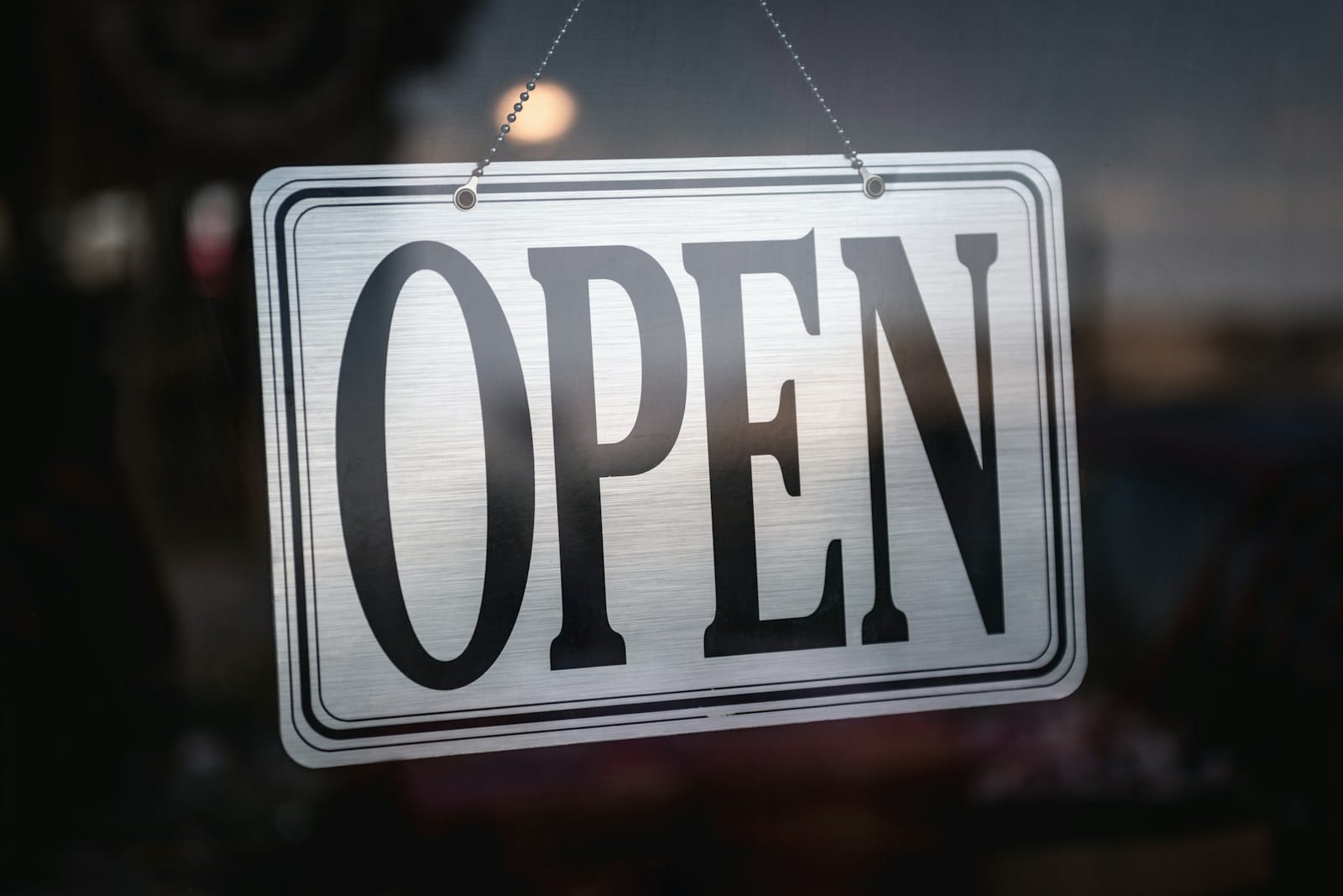 ガラスの戸に掛けられた「OPEN」の札