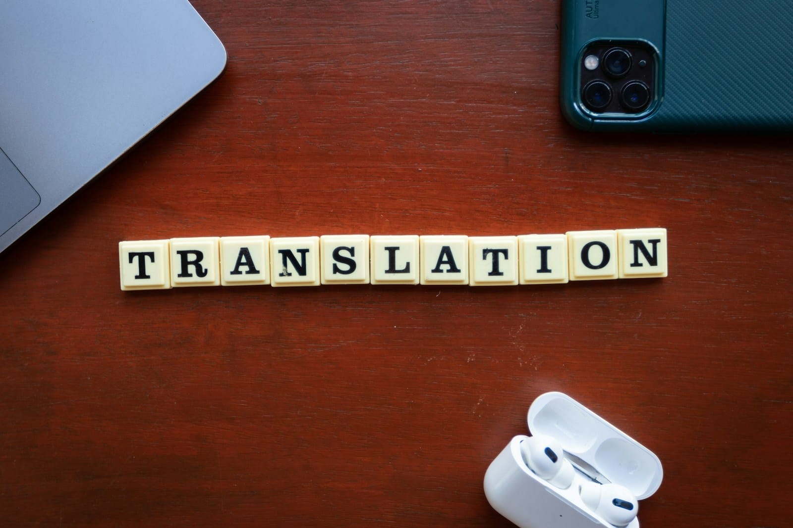 テーブルに置かれた「TRANSLATION」の文字の木の駒とスマートフォン