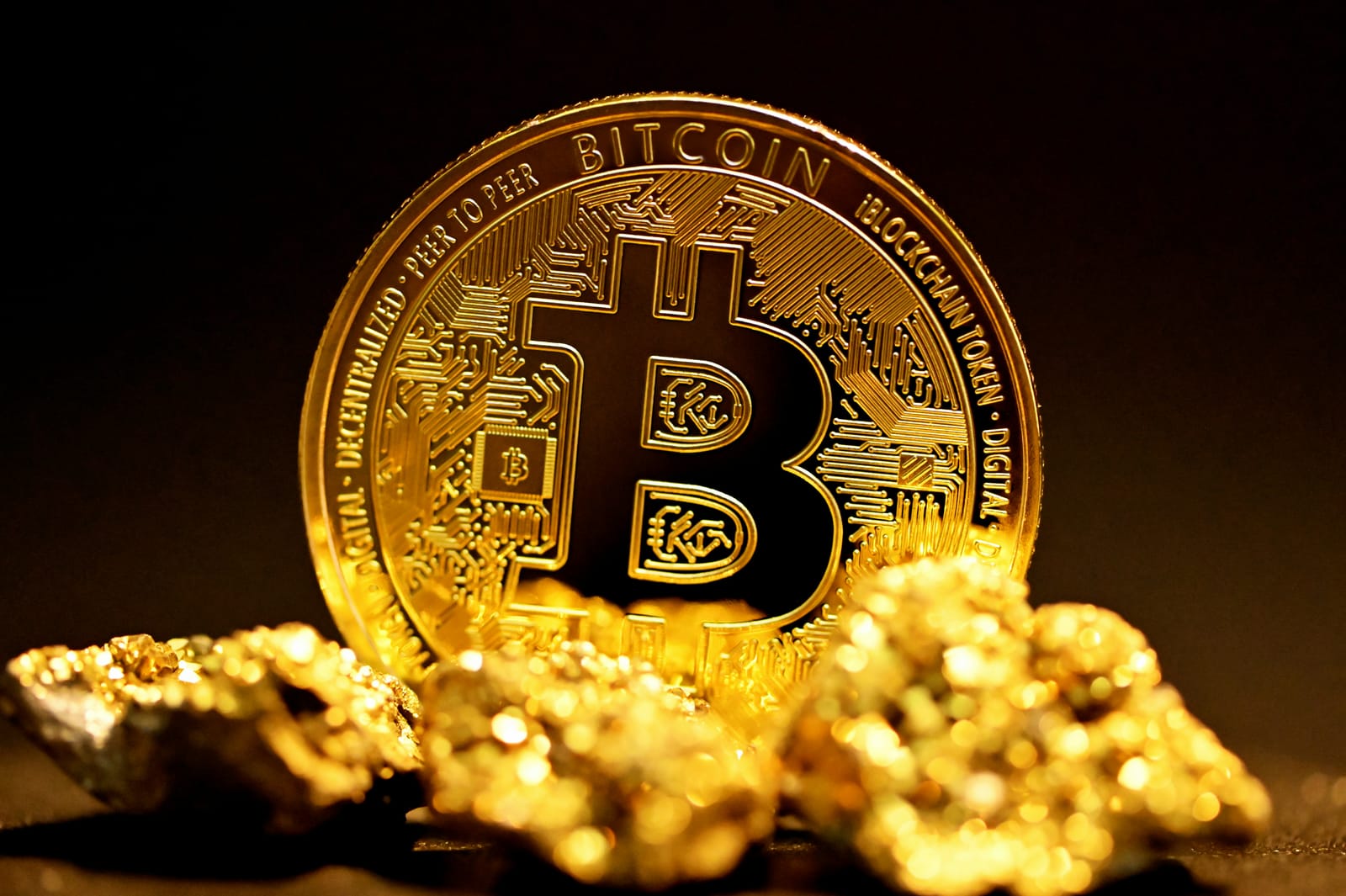 金の粒の上に置かれたビットコインの写真
