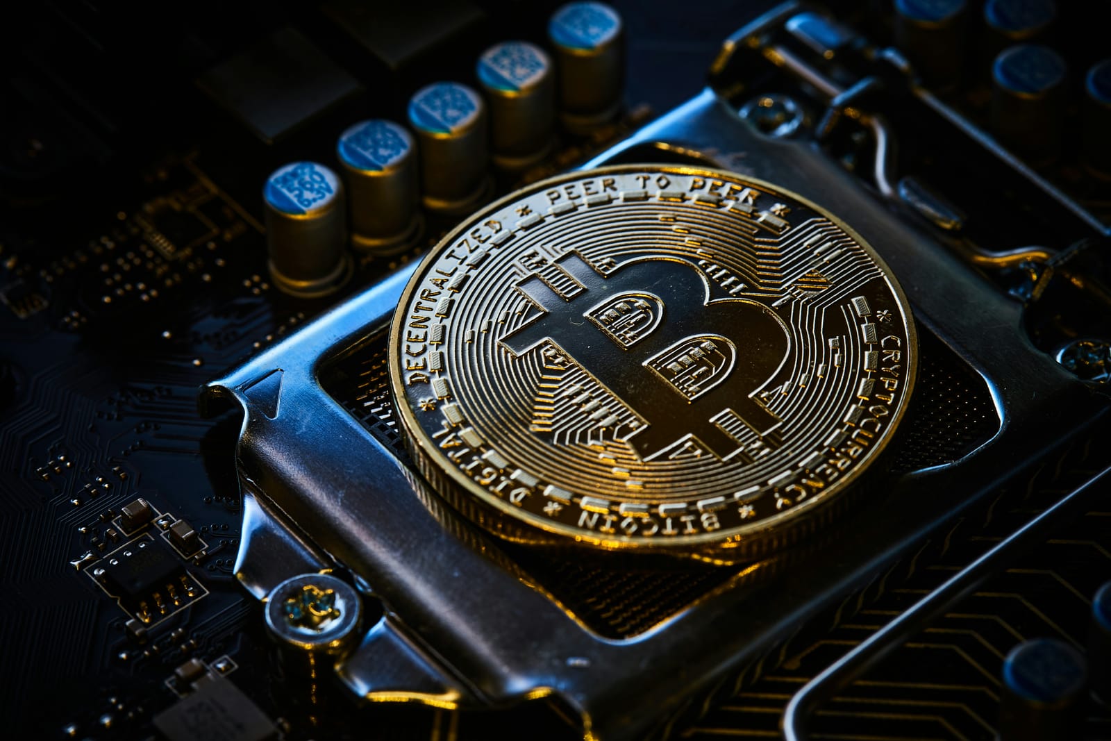 コンピューターの基板の上に置かれたビットコインの写真