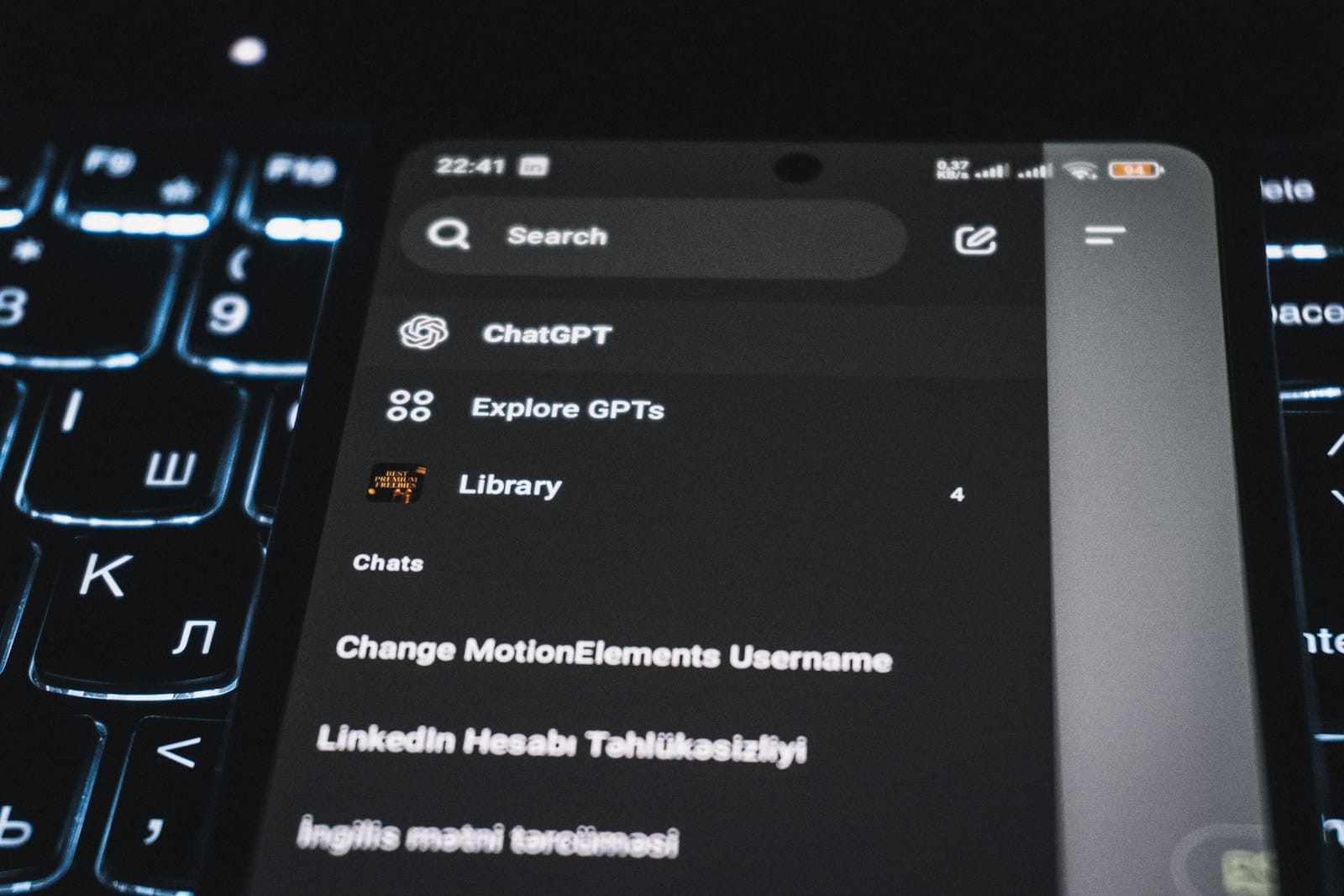 キーボードの上に置かれたスマートフォンに、ChatGPTの画面が映っている