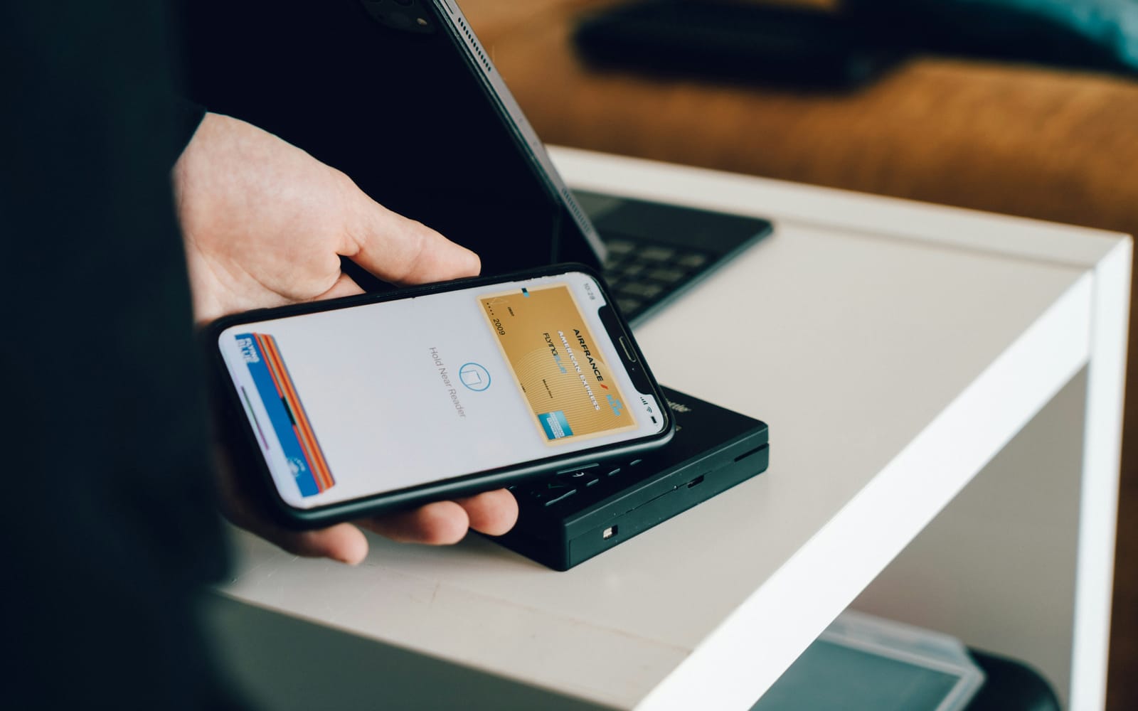 スマートフォンを決済端末にかざして支払っている場面